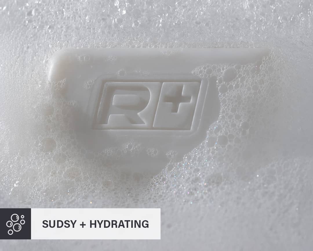 Bar of RGMN+ Gladiator soap on a sudsy white background