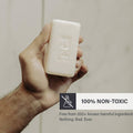 Thumbnail for Hand holding a bar of RGMN+ Gladiator soap with a label highlighting its non-toxic properties.