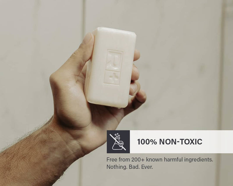 Hand holding a bar of RGMN+ Gladiator soap with a label highlighting its non-toxic properties.