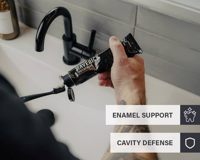 Person holding a tube of RGMN+ toothpaste with text about enamel support and cavity defense.