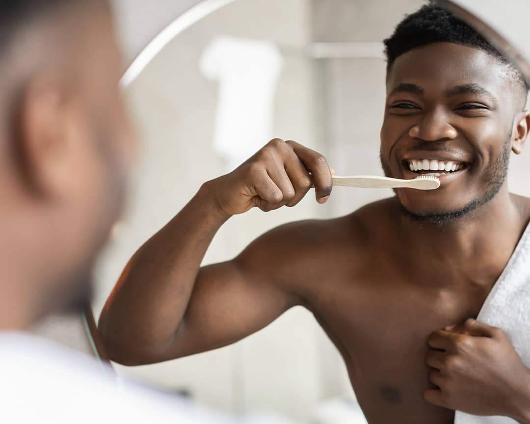 Man brushing his teeth in front of a mirror