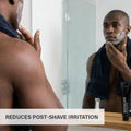 Thumbnail for Man applying RGMN+ Neutralizer to his face with text labeled 'Reduces post-shave irritation' on a bathroom counter.